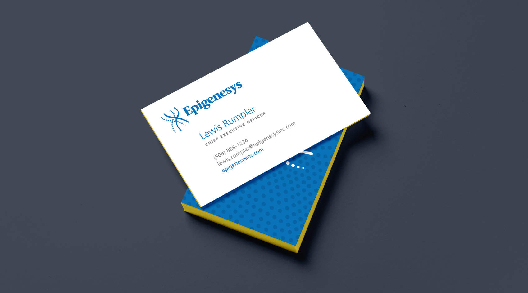 The front of a business card with the Epigenesys logo, sitting on top of another business card with a blue backing.