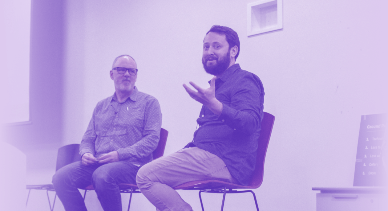 A photo of Alex Carr answering a question while sitting with Gorham Palmer.